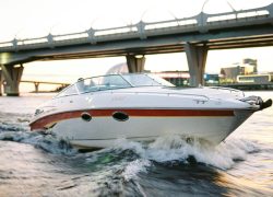 pexels photo 10955648 10955648 A sleek motorboat speeding under a modern bridge during daylight, showcasing cityscape.